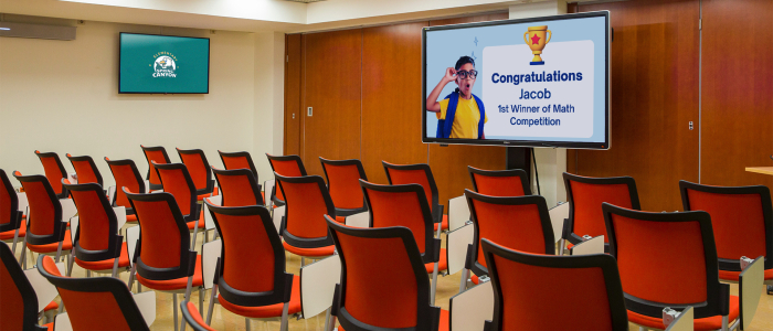 Two digital displays are installed in the classroom. One shows the school’s name & the other is a student recognition board