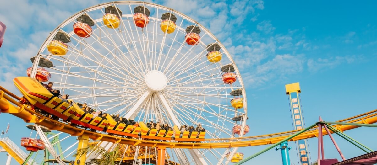 Theme park image displaying two rides, giant wheel and roller coaster