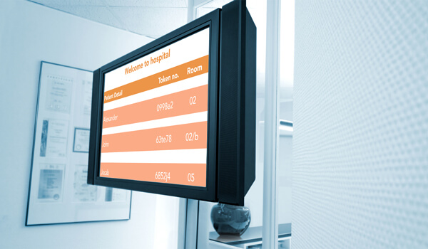 hospital waiting room with digital signage screen showing token numbers for patients to maintain proper queue