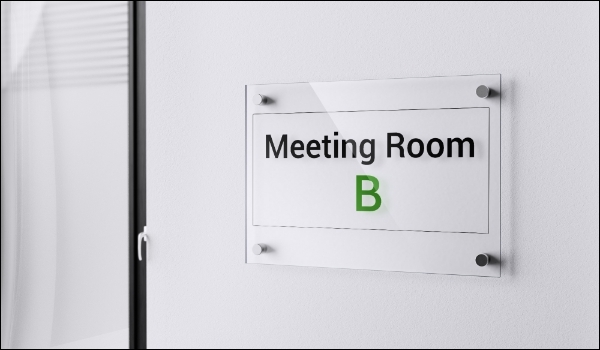 A glass door signage outside a corporate office conference room reads 'Meeting Room B'