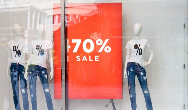 A window display outside a retail store shows 70% sale on products