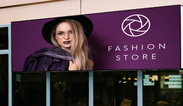 A purple vinyl banner shows the name & logo of a fashion brand outside a retail store