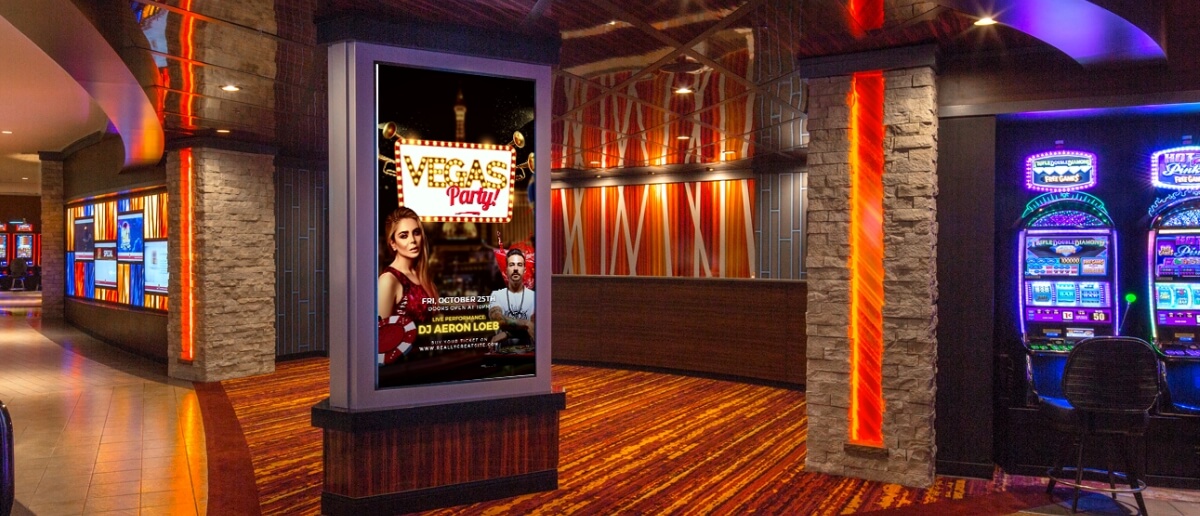 A digital signage inside a casino lobby advertises an event using a digital poster