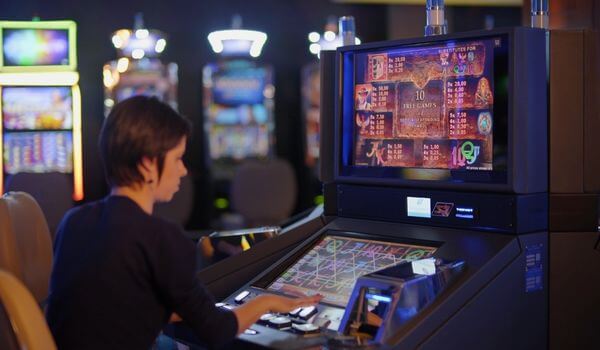  A woman interacts with a digital screen inside a casino game station