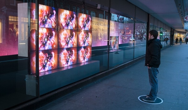 A man looks at the video wall installed in the window of a John Lewis store as it displays stunning visuals
